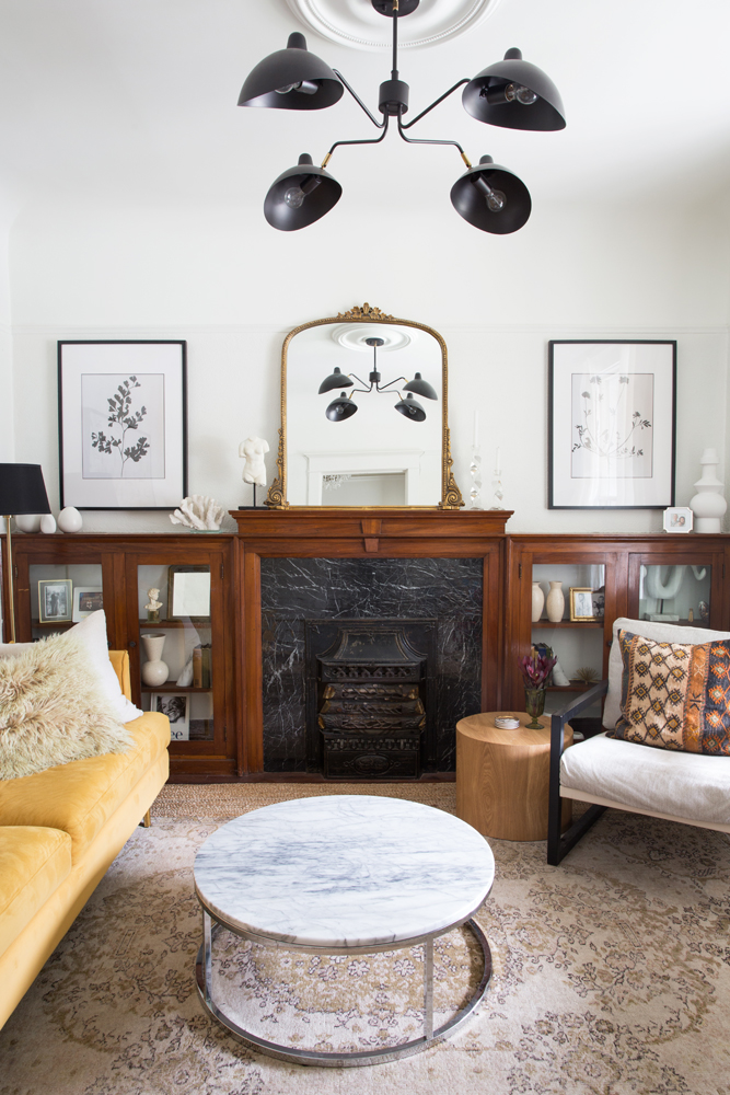 Historic Haute Fireplace mantel adorned with vintage pieces and gold French mirror.