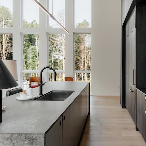 It’s ‘Brutal’ in Here A bright kitchen with a concrete kitchen island and black cabinets