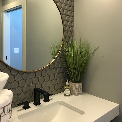 Tile With Style A modern bathroom with grey wall tiles and a round mirror over the sink