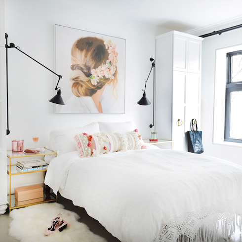 Oppositional Design White bedroom with black sconces and art of back of woman's head with flowers in hair