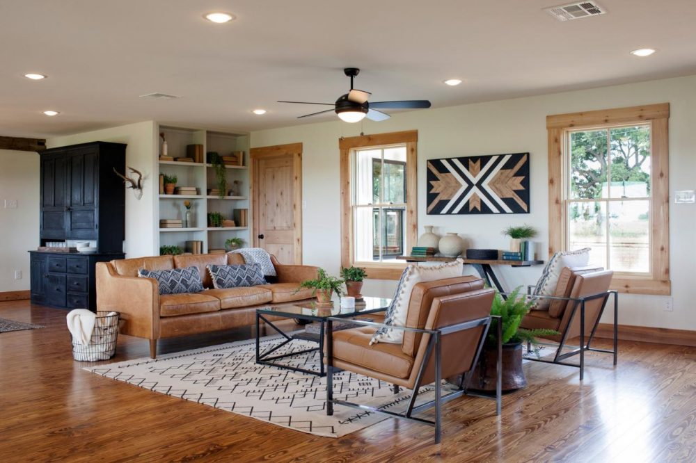 Styling Strategy living room with two wood framed windows and tan leather furniture