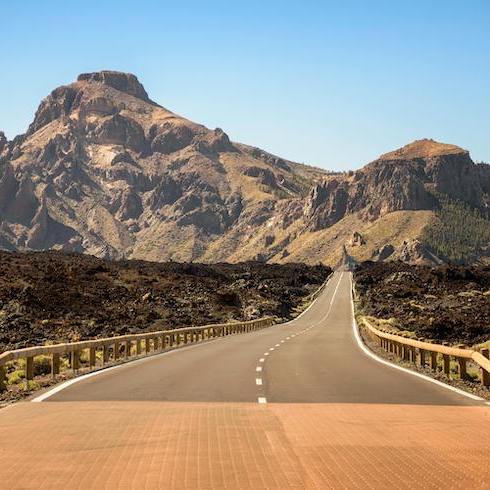 7. Canary Islands, Spain Gray Asphalt Road Towards Brown Mountain on Tenerife, Spain, as part of HOME Network's 10 Unexpected Sunny Destinations For Your Winter Escape