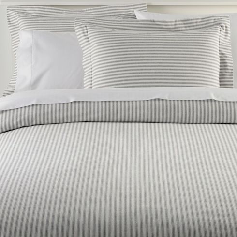 Best in Snow L.L.Bean’s Ultrasoft Comfort Flannel Comforter and pillow cases in Feldspar grey stripe sit on a white bed with white sheets and pillow cases