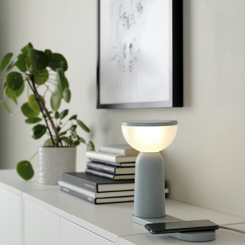 Light Up My Life IKEA's BETTORP LED mobile lamp sits on a credenza with a stack of books, a potted plant, and framed print on the wallas part of HGTV's 10 Gift Ideas for the Women in Your Life