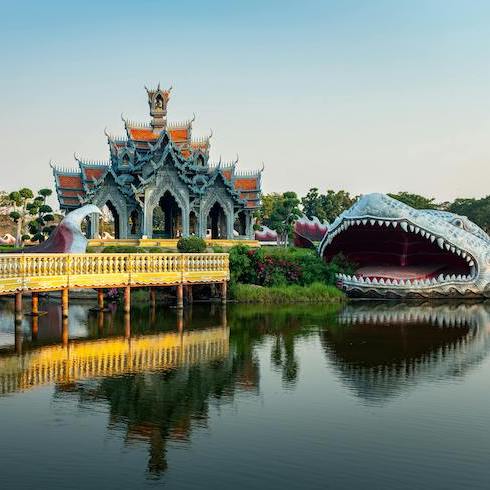 9. Bangkok, Thailand Ancient city in Bangkok Thailand, with a temple and large dragon sculpture in the water as part of HOME Network's 10 Unexpected Sunny Destinations For Your Winter Escape