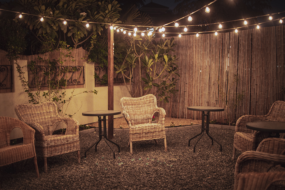 Chic Bamboo Screening Nighttime shot of a yard with wicker chairs and strings of fairy lights all fenced in by a bamboo screening fence.