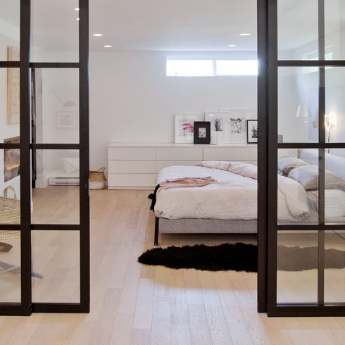 Glass Doors Glass doors separate the bedroom from the living area in a basement apartment