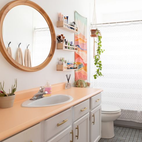 Work With What You’ve Got bright bathroom with small shelves on wall and peach-counter vanity