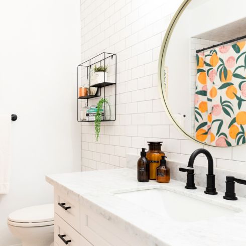 Double Duty Modern white bathroom with large white vanity, black fixtures and gold round mirror