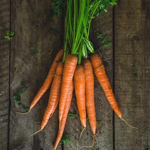 Carrots A pile of orange carrots with green tops