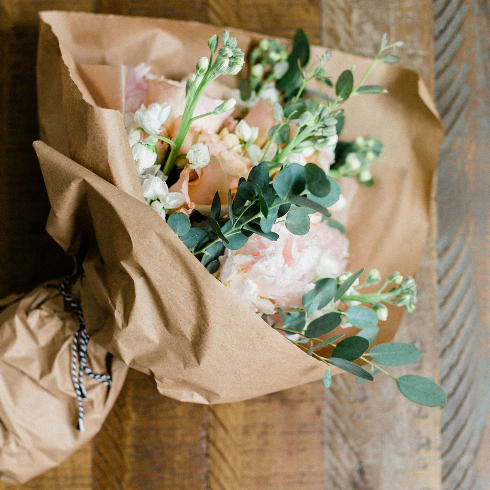 Keep Flowers Hydrated During Transport A bouquet of wildflowers wrapped in brown paper