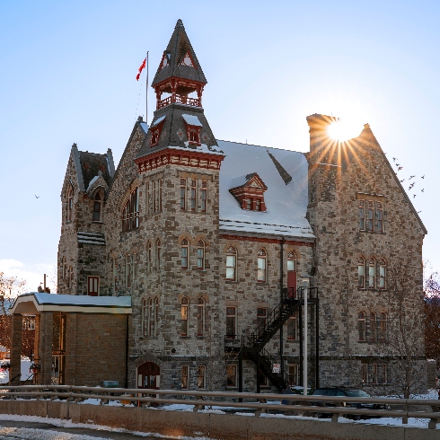 Almonte, Ontario Almonte, Ontario's town hall in winter topped with snow and the sun shining behind it.