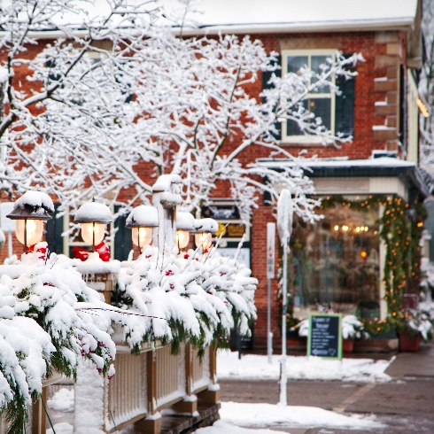 Niagara-on-the-Lake, Ontario A wintery Queen Street in Niagara-on-the-Lake, Ontario with red buildings and snow-covered trees.