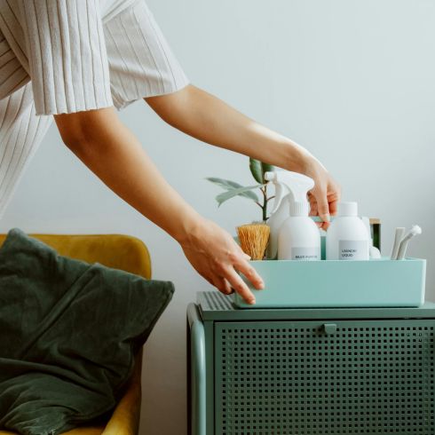 Utilize Clever Storage Solutions A woman organizes bath products in a small bin.