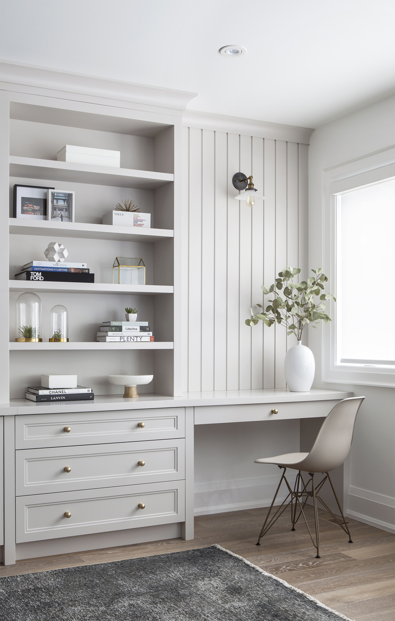 Let it Shine An airy living room with a nook for a desk and bookshelf with a sprig of eucalyptus in the corner of the desk