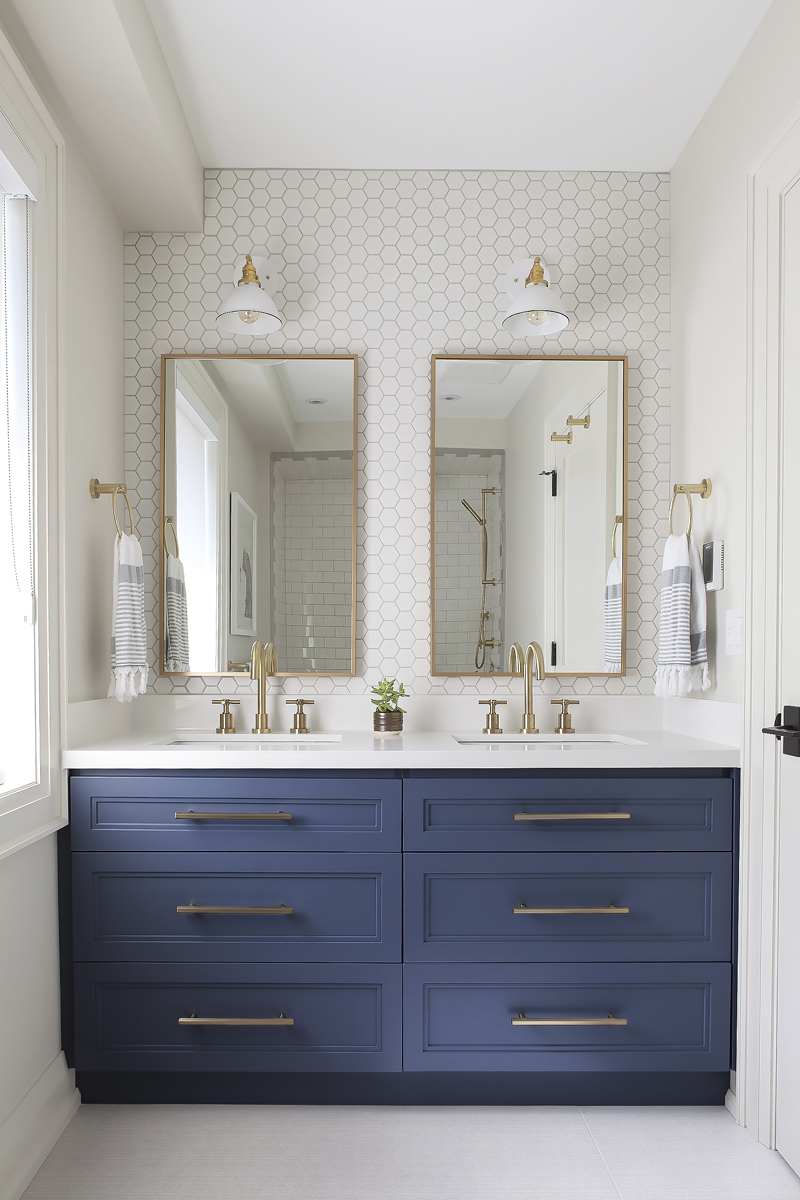 All Grown Up A grown-up kids' bathroom with deep blue cabinets and hexagonal backsplash tiles