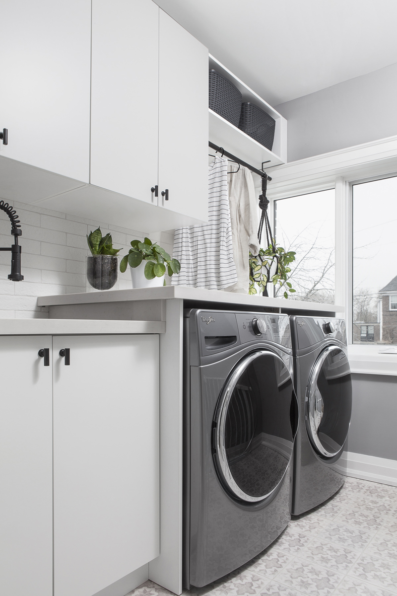 Laundry With a View A sleek laundry room with plants, patterned tiled flooring and white cabinets