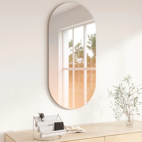 Gradient Mirror An oval-shaped mirror mounted on the wall.