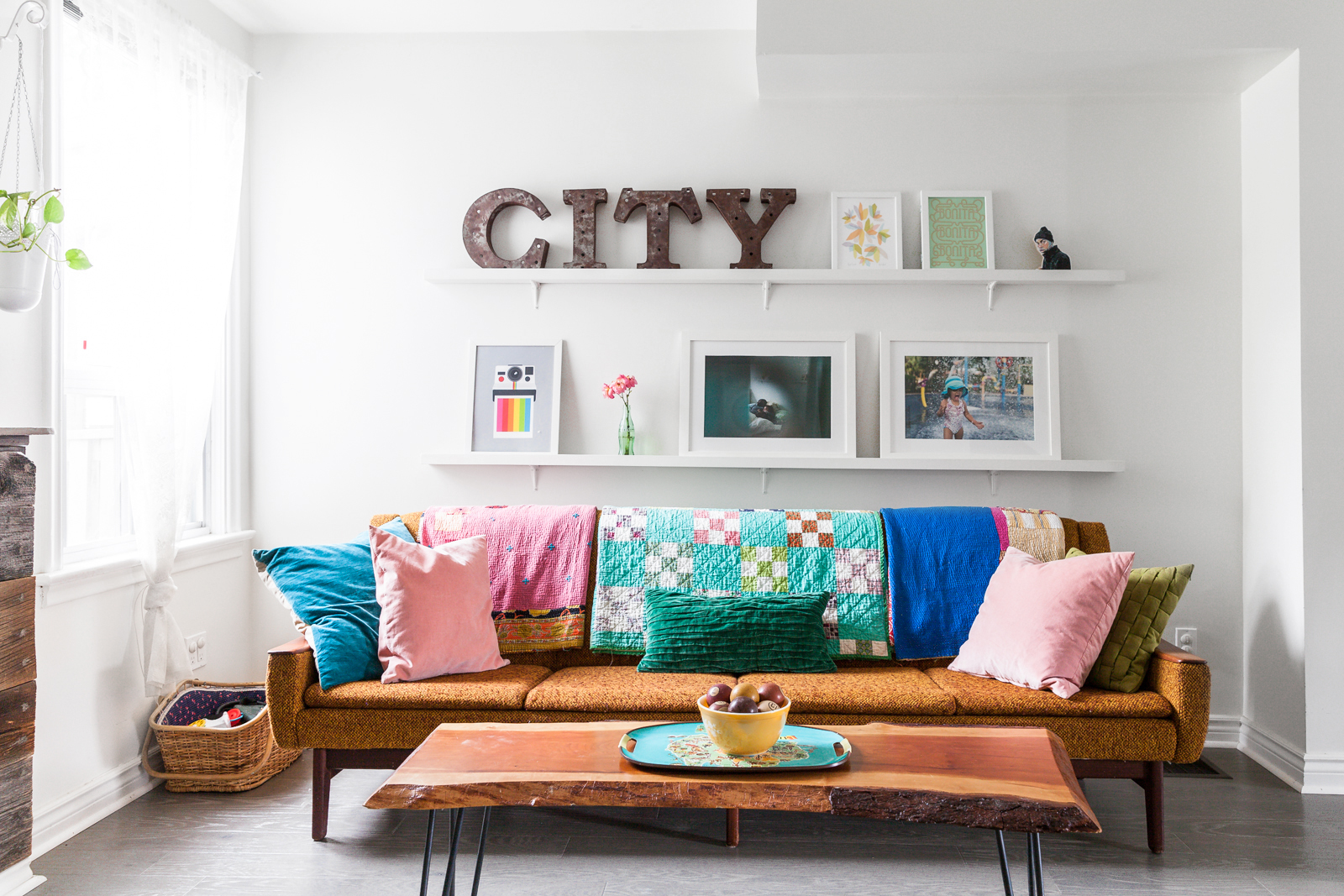 Party of Four white living room with vintage sofa and floating shelves with CITY letters