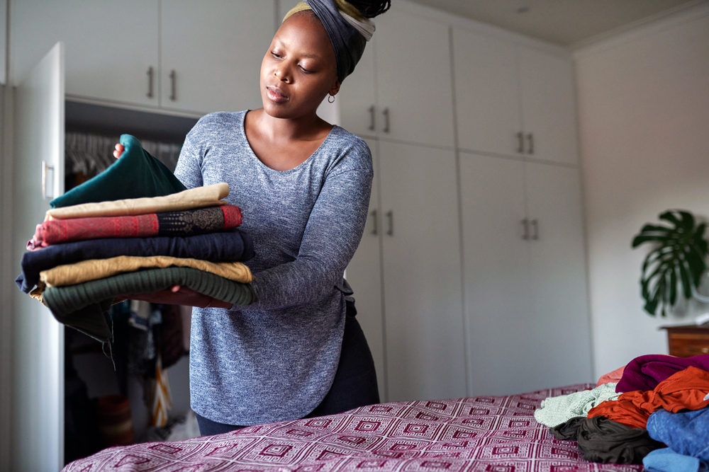 Choose a Decluttering Strategy Young woman organizing her room