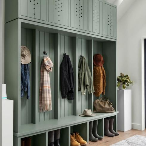 Design a Fully Functional Family Mudroom Green mudroom with shoe storage and coat hooks