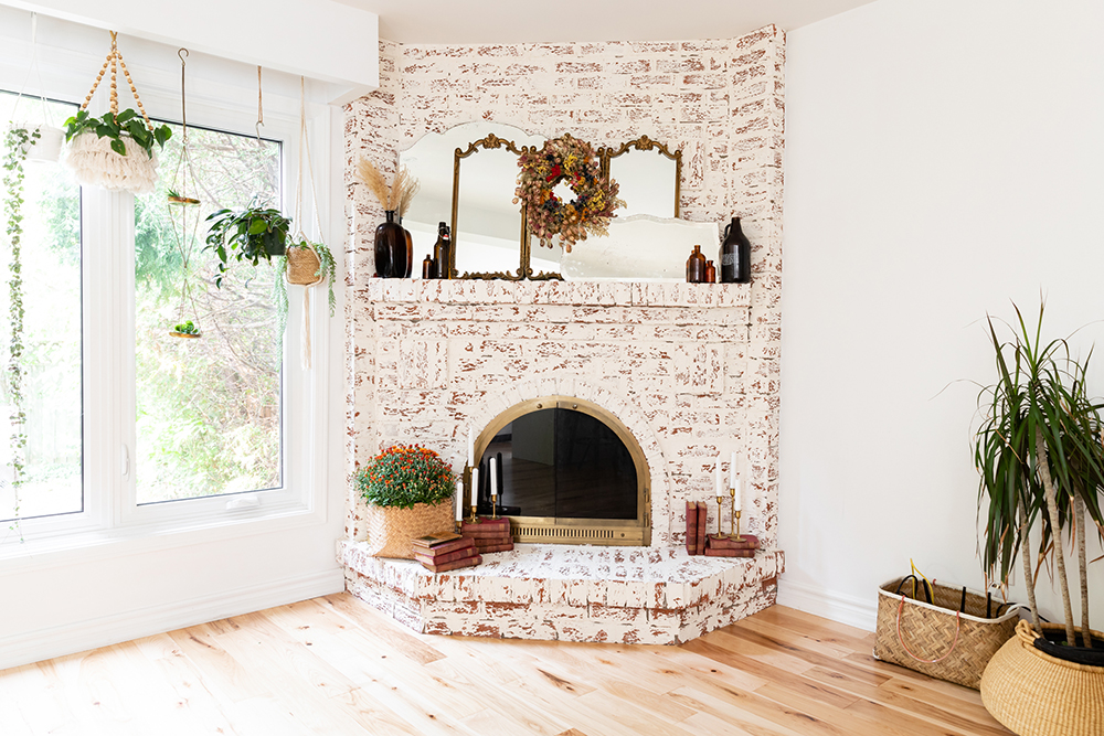 Brighten the Brick Bright living room with a brick fireplace smeared white. Around the fireplace are a number of plants in various sizes