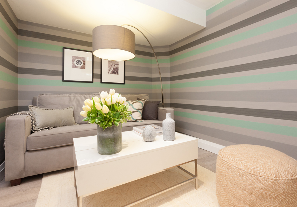 Between the Lines grey and green striped walls with grey sofa and white table