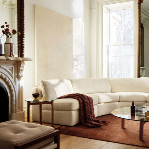 EQ3 Living room featuring white coach, wooden coffee table with glass top in a sophisticated living room.