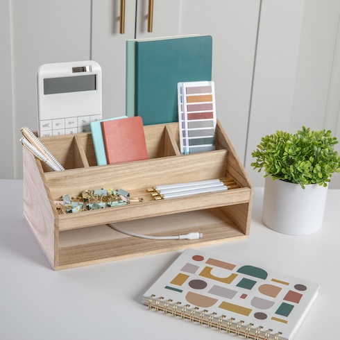 Declutter Your Desk Assorted pens and desktop items are organized in a wood desktop organizer.