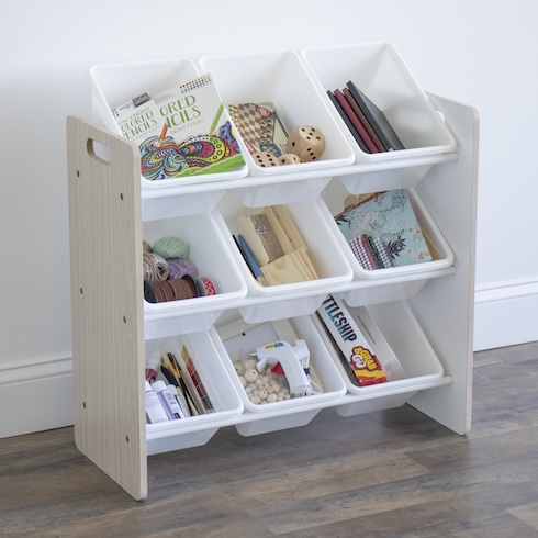 Tame the Toys An array of books, toys, and art supplies sit in white bins in a three-tier toy organizer.
