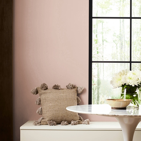 Natural Hues and Earthy Tones A small dining nook with bench seating, round table, a large window and sandy-toned walls