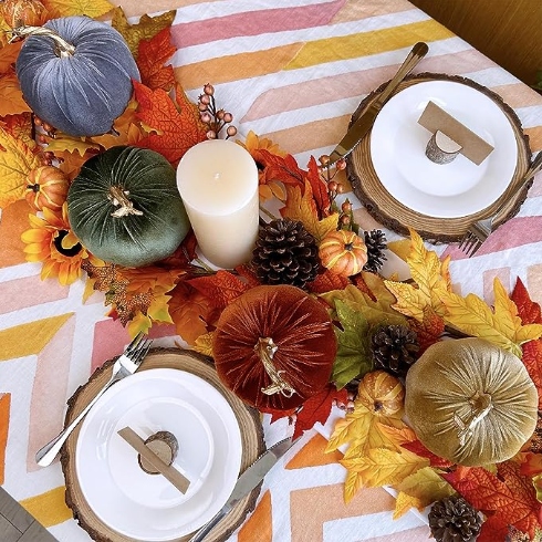 Silky Velvet A tablescape with two dinner plates and a centrepiece featuring four velvet pumpkins
