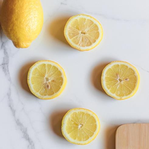 1. Banish Sink Stink With Lemons sliced lemons on a white counter