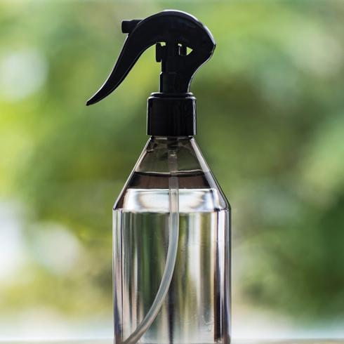2. Clean Windows With Vinegar a spray bottle full of vinegar by a window