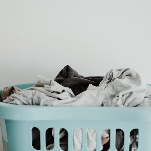 8. Brighten Your Laundry With Baking Soda a blue laundry basket filled with laundry