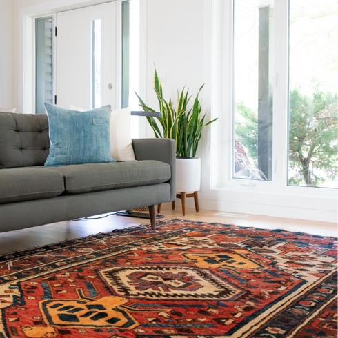 6. Clean Carpet Stains With Vodka a living room with a gray couch and red carpets