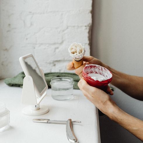 7. Clean Stains With Shaving Cream a person stirring shaving cream