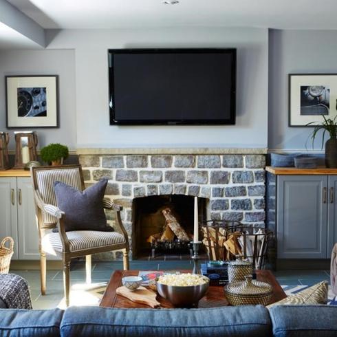 Finishing a Basement is Always a Good Idea When it Comes to ROI Basement living room with stone fireplace and blue colour scheme
