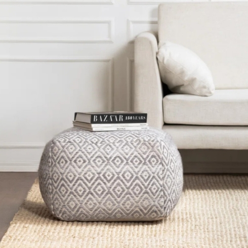 Neutral is Key Gray upholstered pouf on a carpet.