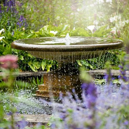 Soothing Sounds Beautiful garden fountain surrounded by colourful flowers as part of memorial garden ideas