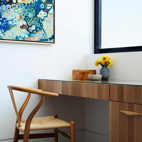 Add a Home Office to an Underused Space Simple home office with modern desk under a window and a wishbone chair