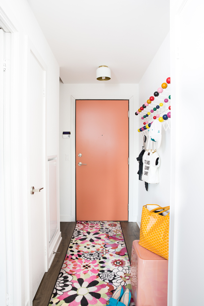 Paint the Door Pink-painted door with flowery rug in foyer