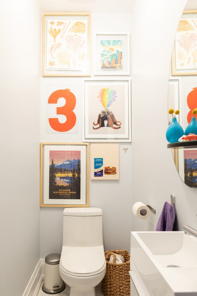 Powder Play Grey bathroom with colourful gallery wall above toilet