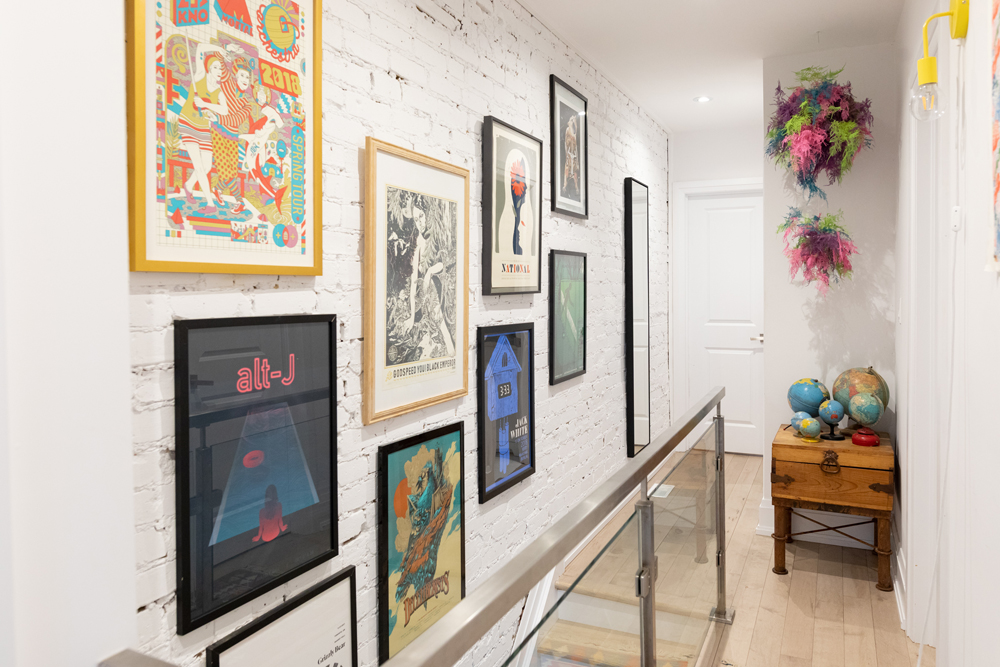 All the Right Notes Top of stairs with gallery wall of art and white painted brick wall