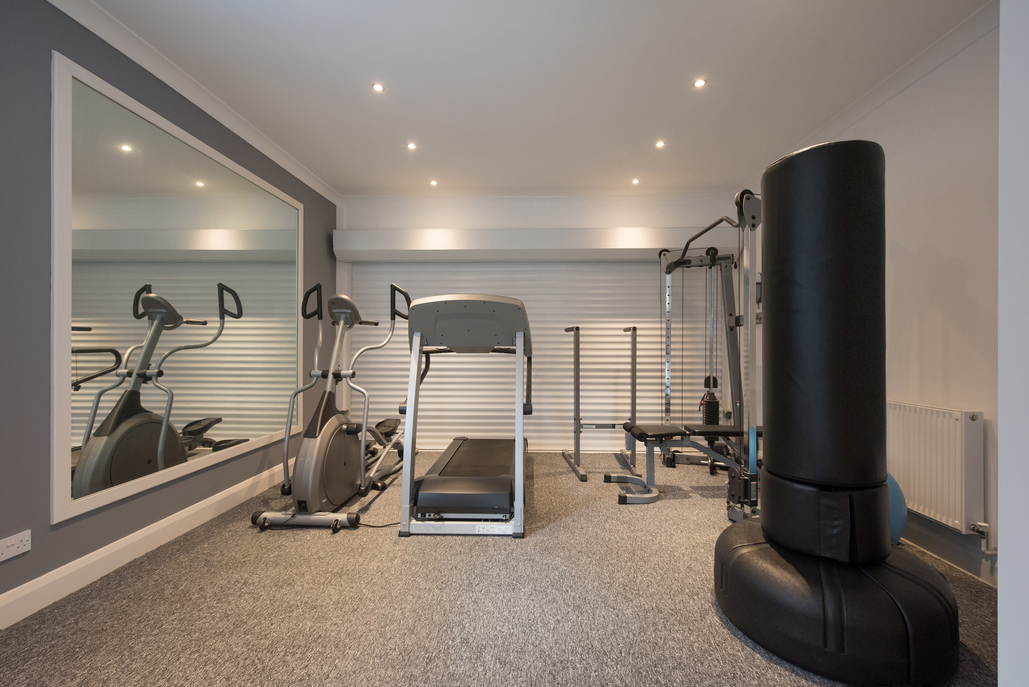 Punch This Home gym with grey floor and big mirror
