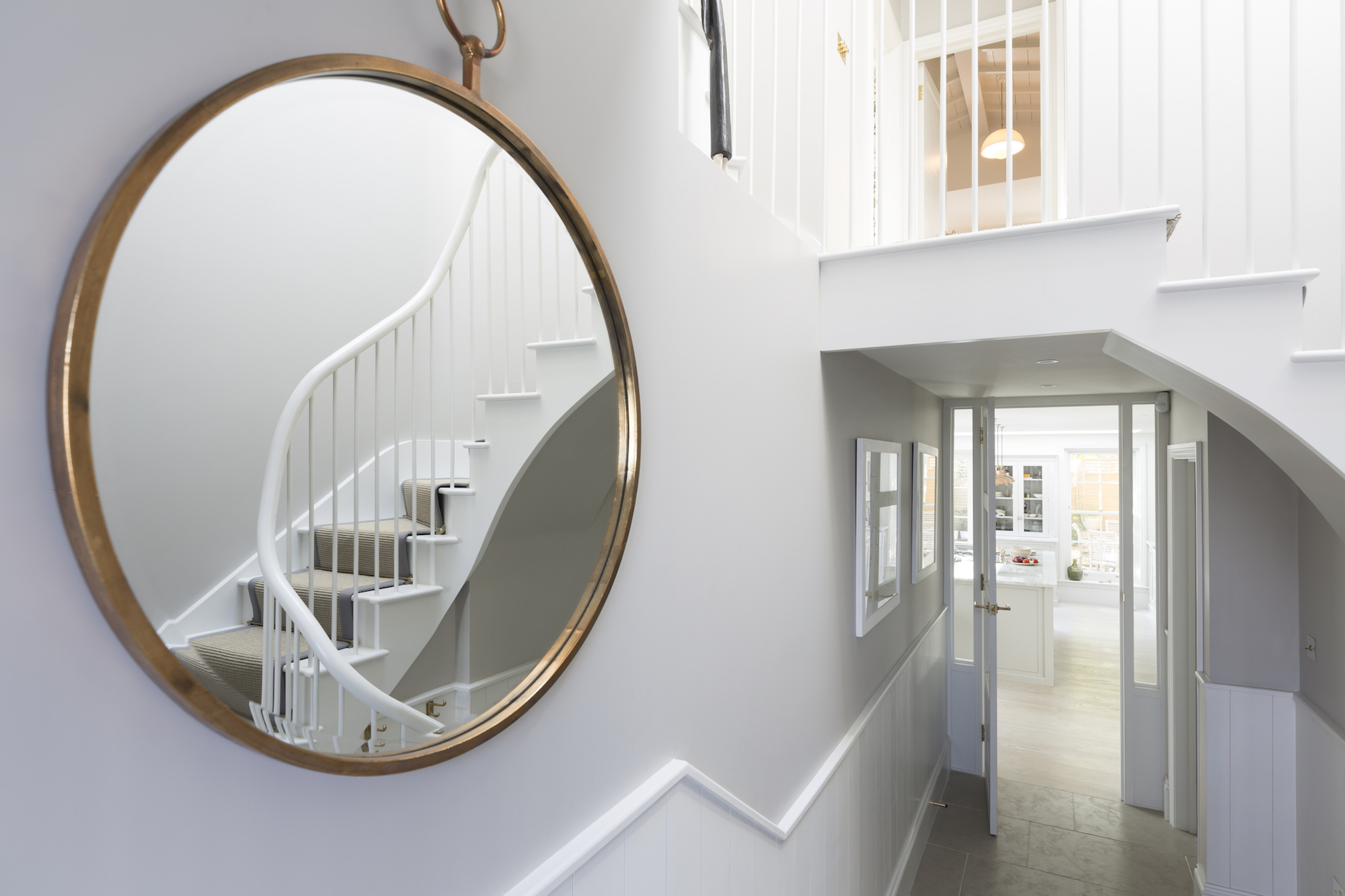 Do Make Use of Mirrors Large round mirror in the hallway of a home