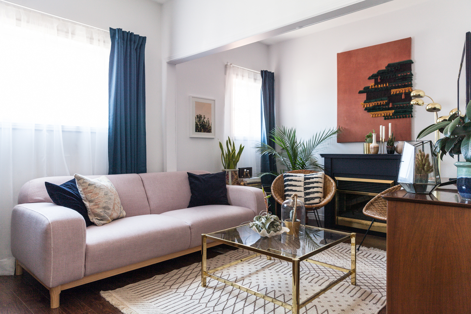 Decor Score living room with lavender sofa, blue drapes and black and brass fireplace