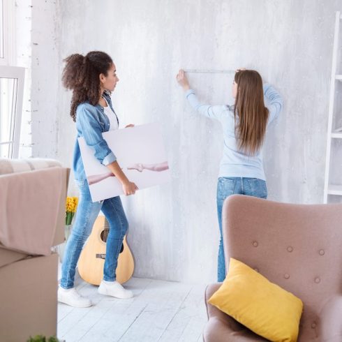 Step Five: Measure and Mark the Spot women measuring wall to hang picture