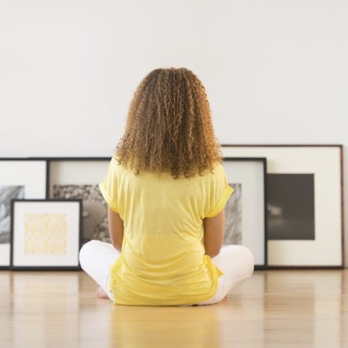 Step One: Strategize Woman sitting on floor looking at frames against white wall