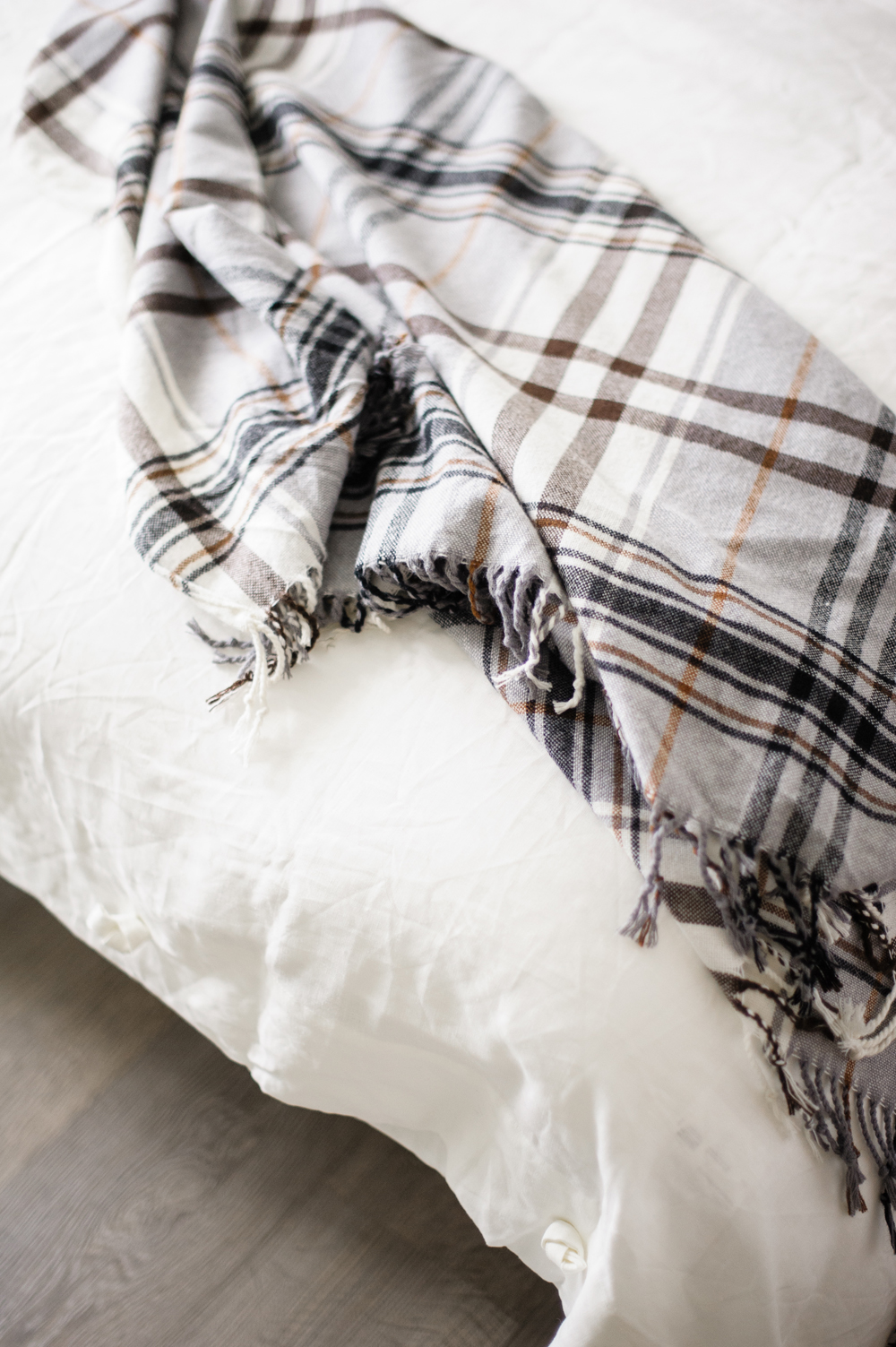 A Throw That’s All Mine Plaid throw tossed across a bed